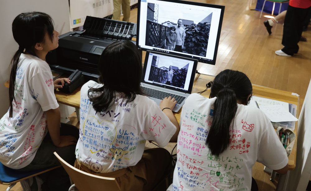 写真のセレクトをする選手の背中は寄せ書きでいっぱい