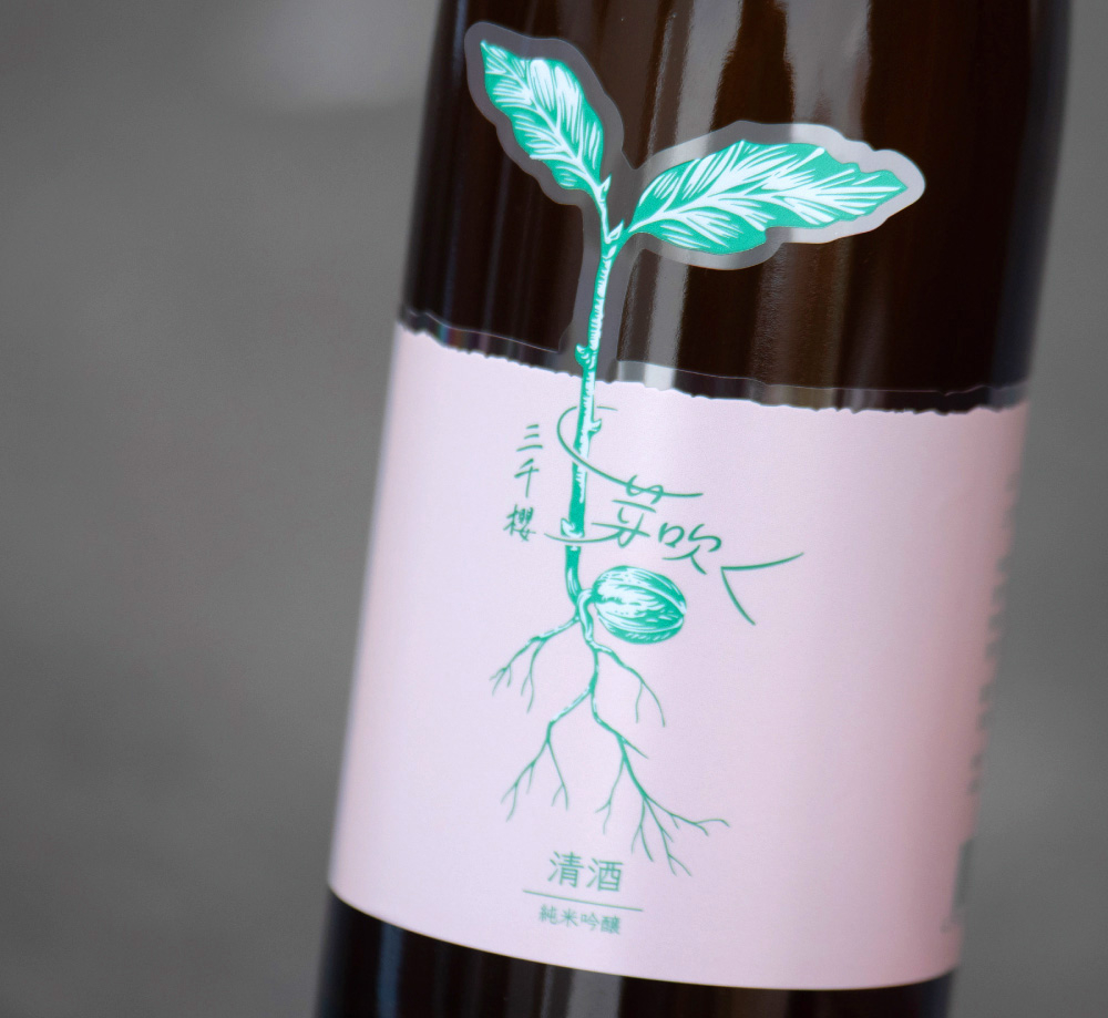 蔵人仕込み原酒「芽吹く」のラベル。どんぐりから新芽と根が伸び、やわらかなふた葉が開いている。