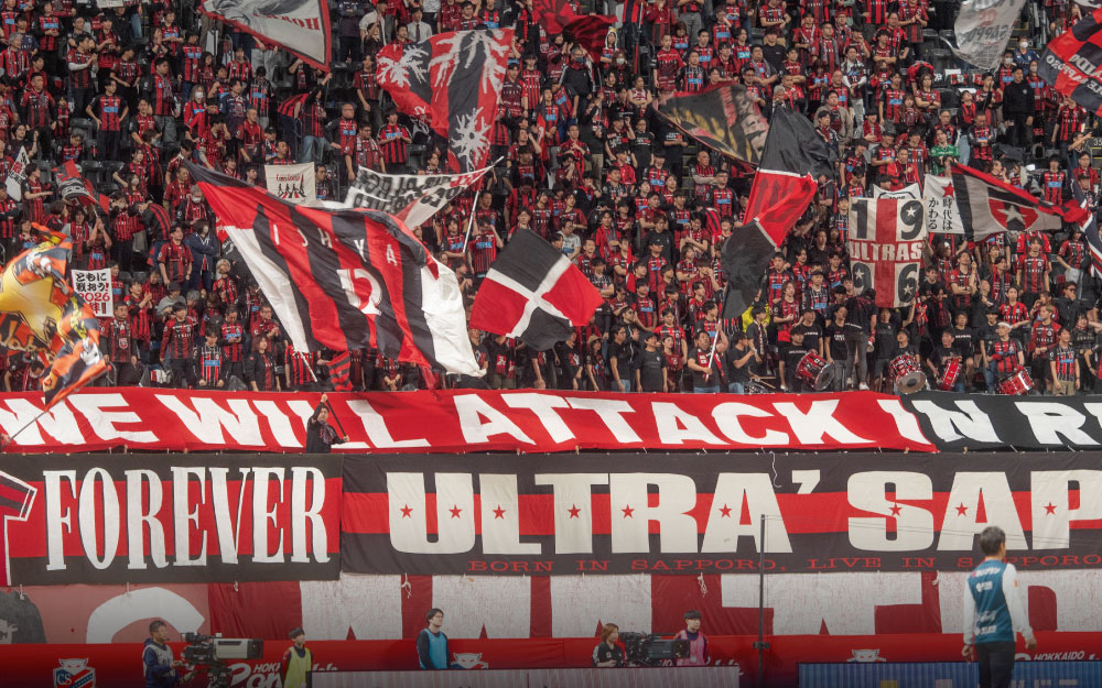 赤と黒のユニフォームを着たサポーターたち